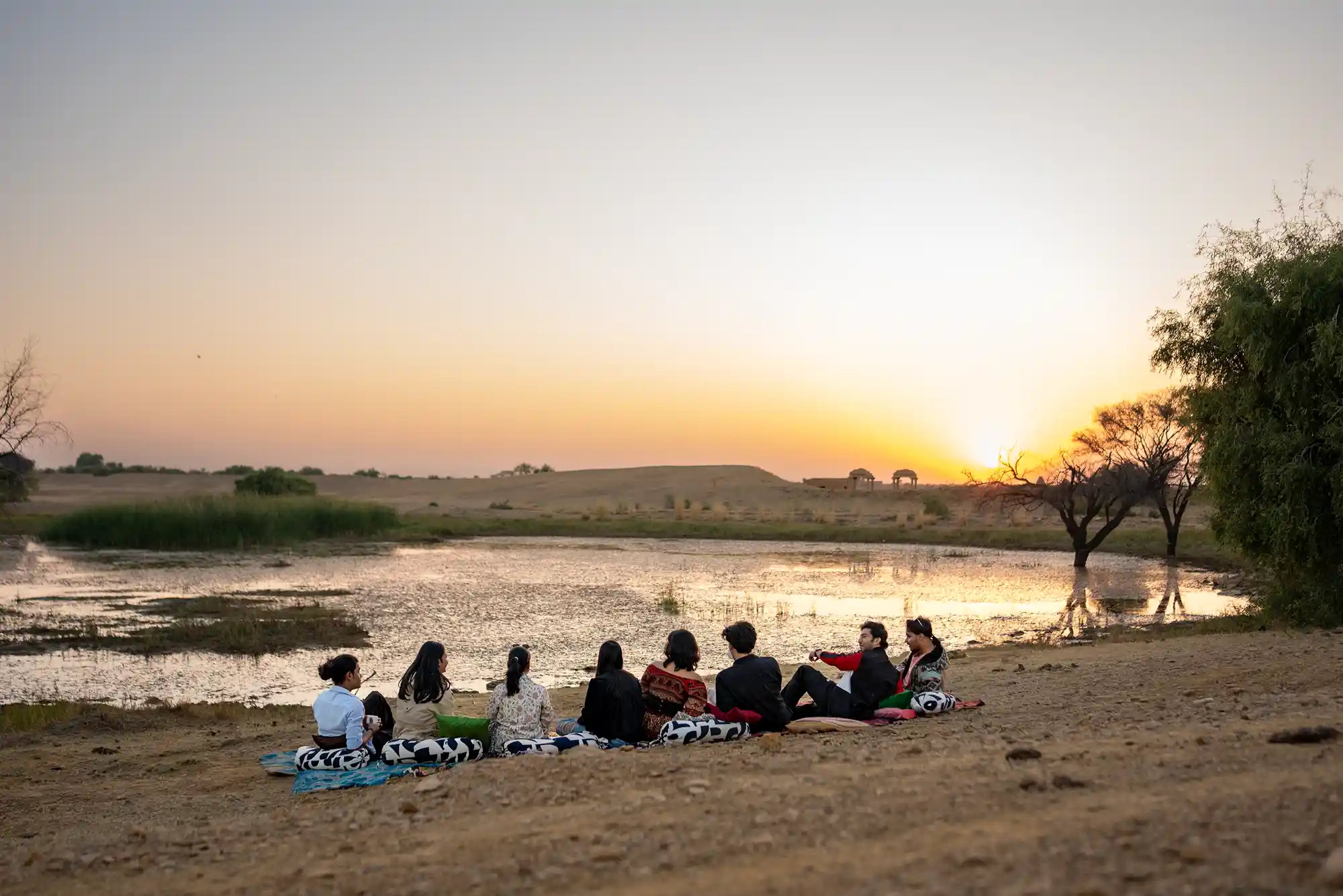 Guests seated on rugs for high tea at oasis near Kuldhara Village Dreamtime Bungalow